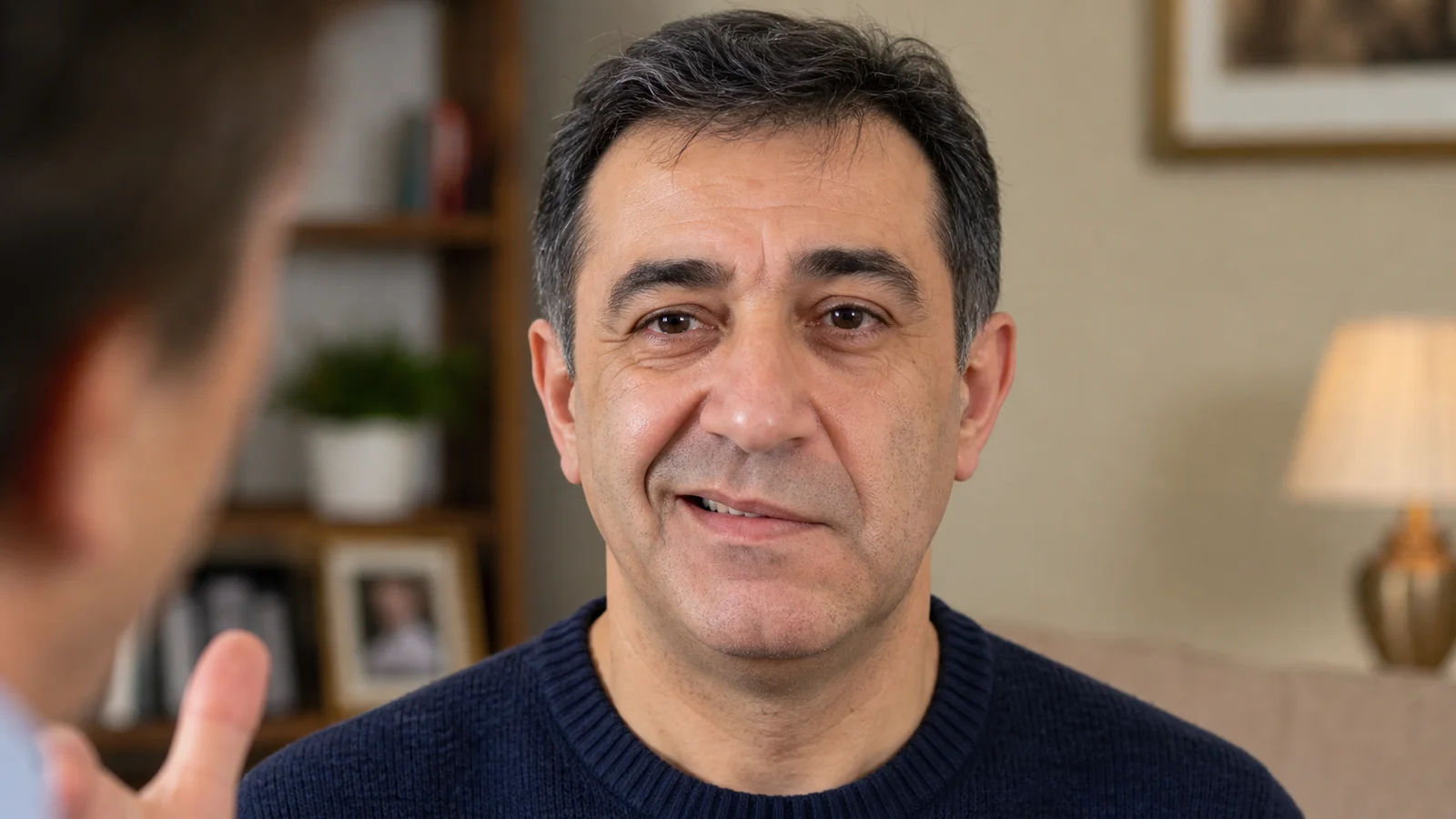 Orta yaşlı bir hastanın yüzü; sol köşesi gülümsemeye çalışırken düşük kalmış, sağ köşesi normal yukarı kalkmış — belirgin yüz asimetrisi.